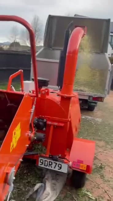 Wood chipper blowing chipped branches into the tipper truck